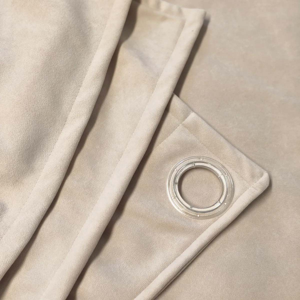 Detail kvalitně zpracovaného textilu s kovovým kroužkem pro snadné a elegantní zavěšení